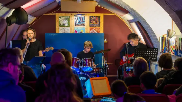 A young drummer performing live at a Planet drum student concert